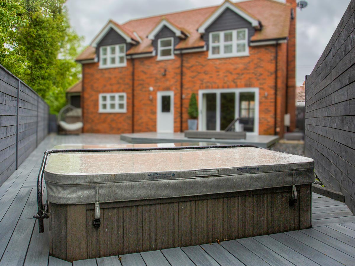 A semi sunken hot tub in the back garden of a new build townhouse