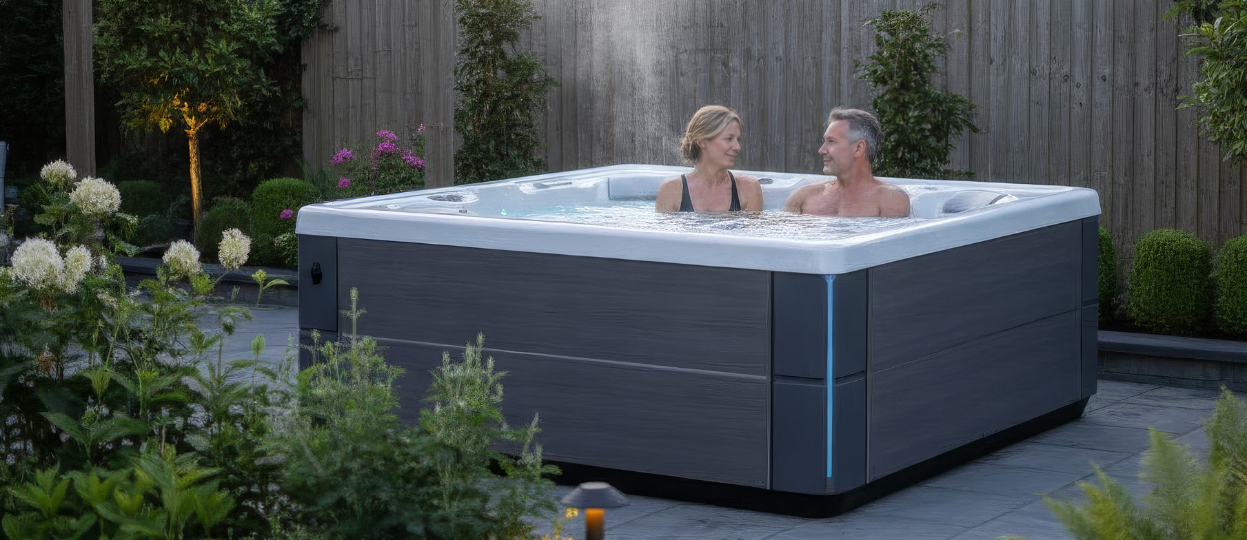 Couple relaxing quietly in a HotSpring hot tub in a peaceful UK garden in the evening