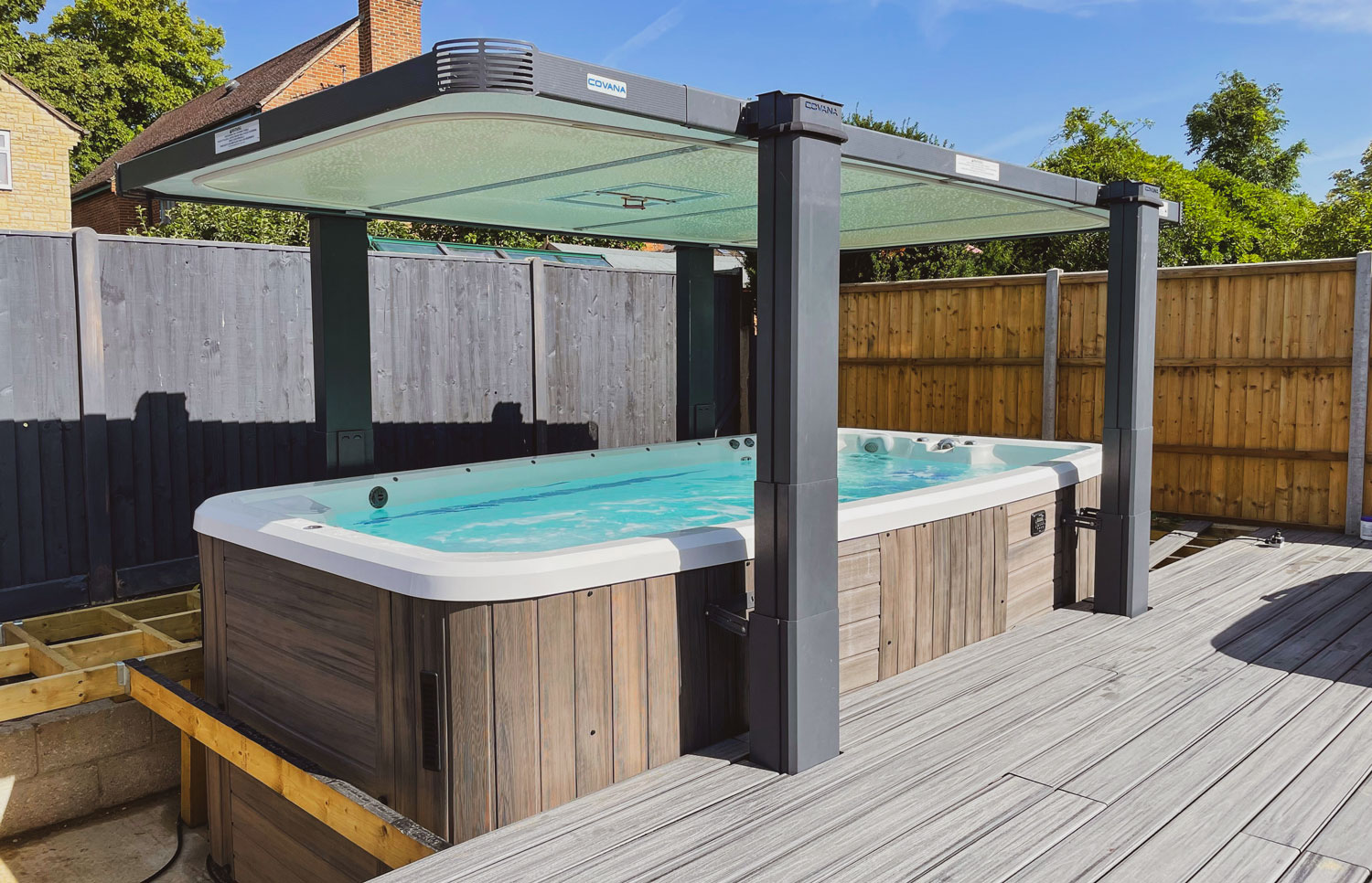 A swim spa on a concrete base with decking being built around it