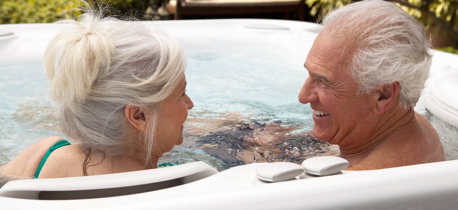 A very fit looking couple of advanced years in a hot tub
