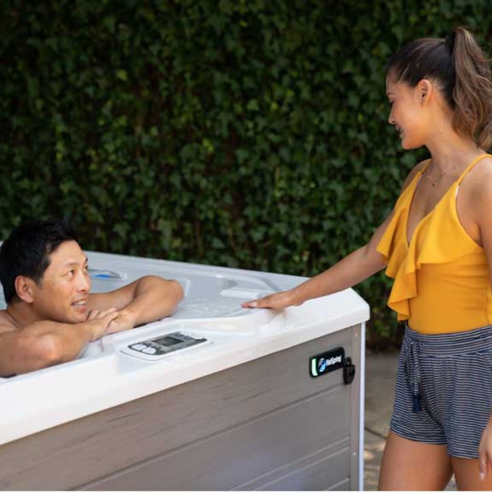 Man in hot tub talking to women outside