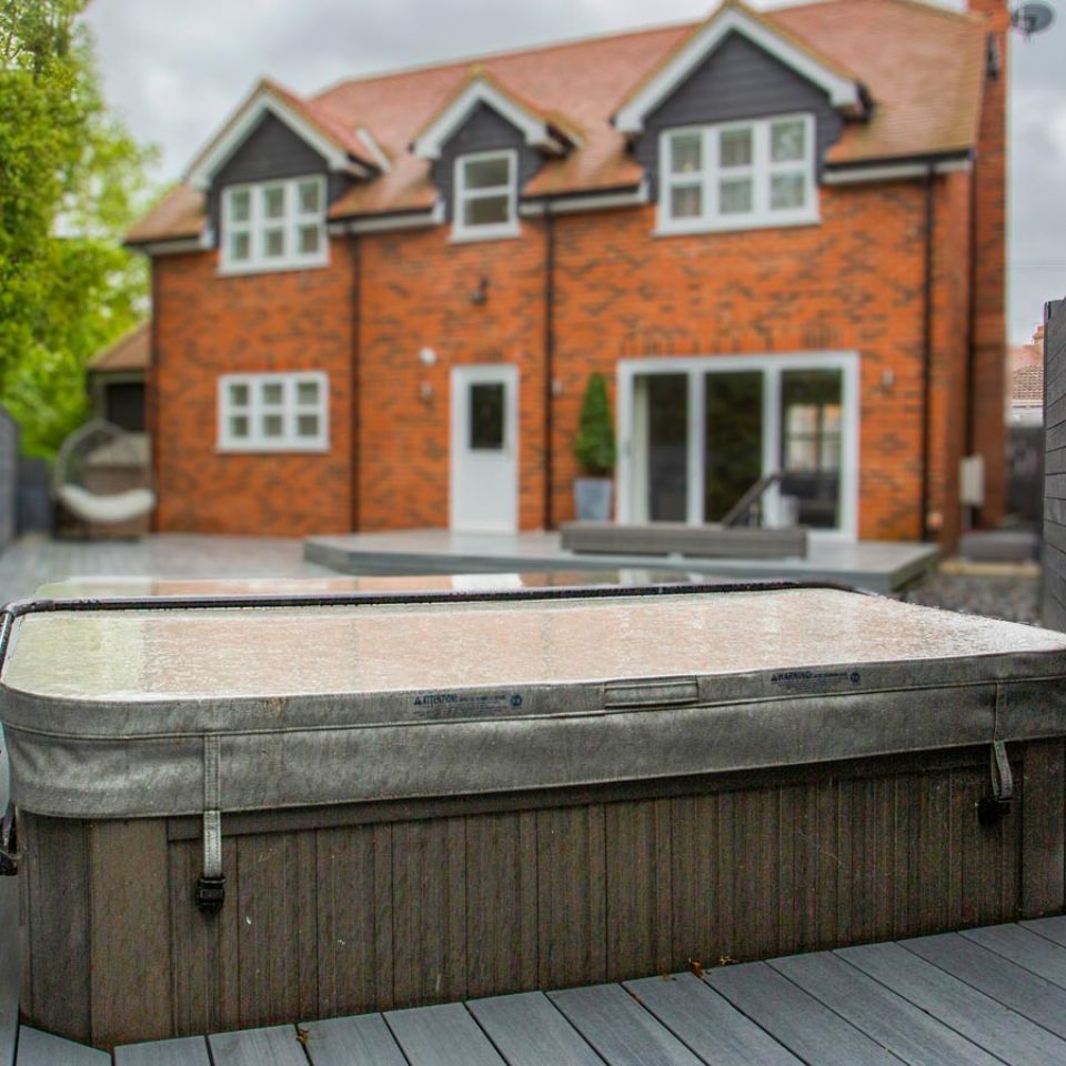 A semi sunken hot tub in the back garden of a new build townhouse