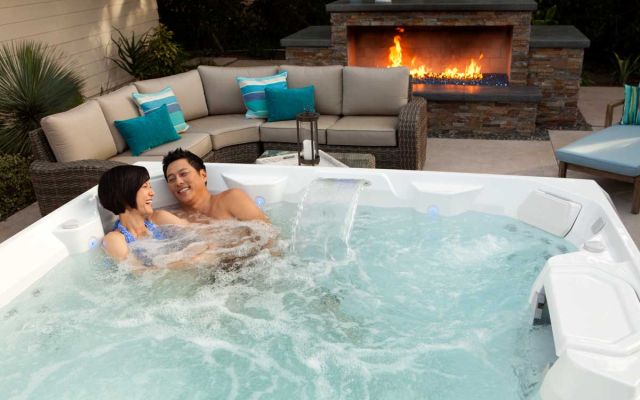 A couple having a laugh in a Limelight Pulse hot tub