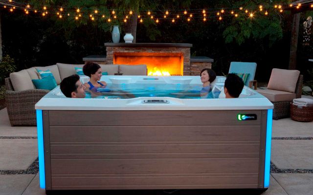 Four friends enjoying time in a Limelight Pulse hot tub of an evening