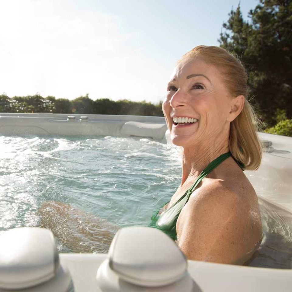 elderly lady enjoying a hot tub in the sun
