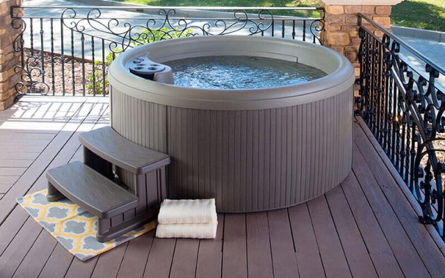 Woman in freeflow hot tub looking at sunset