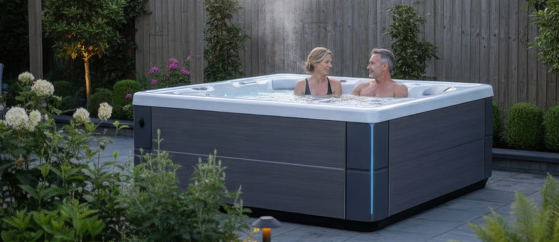 Couple relaxing quietly in a HotSpring hot tub in a peaceful UK garden in the evening