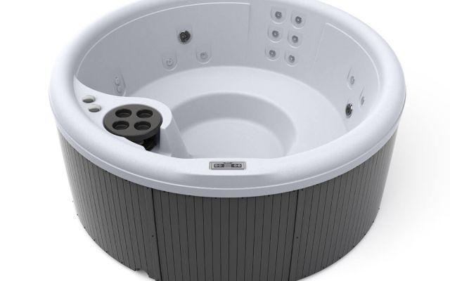 Woman in freeflow hot tub looking at sunset