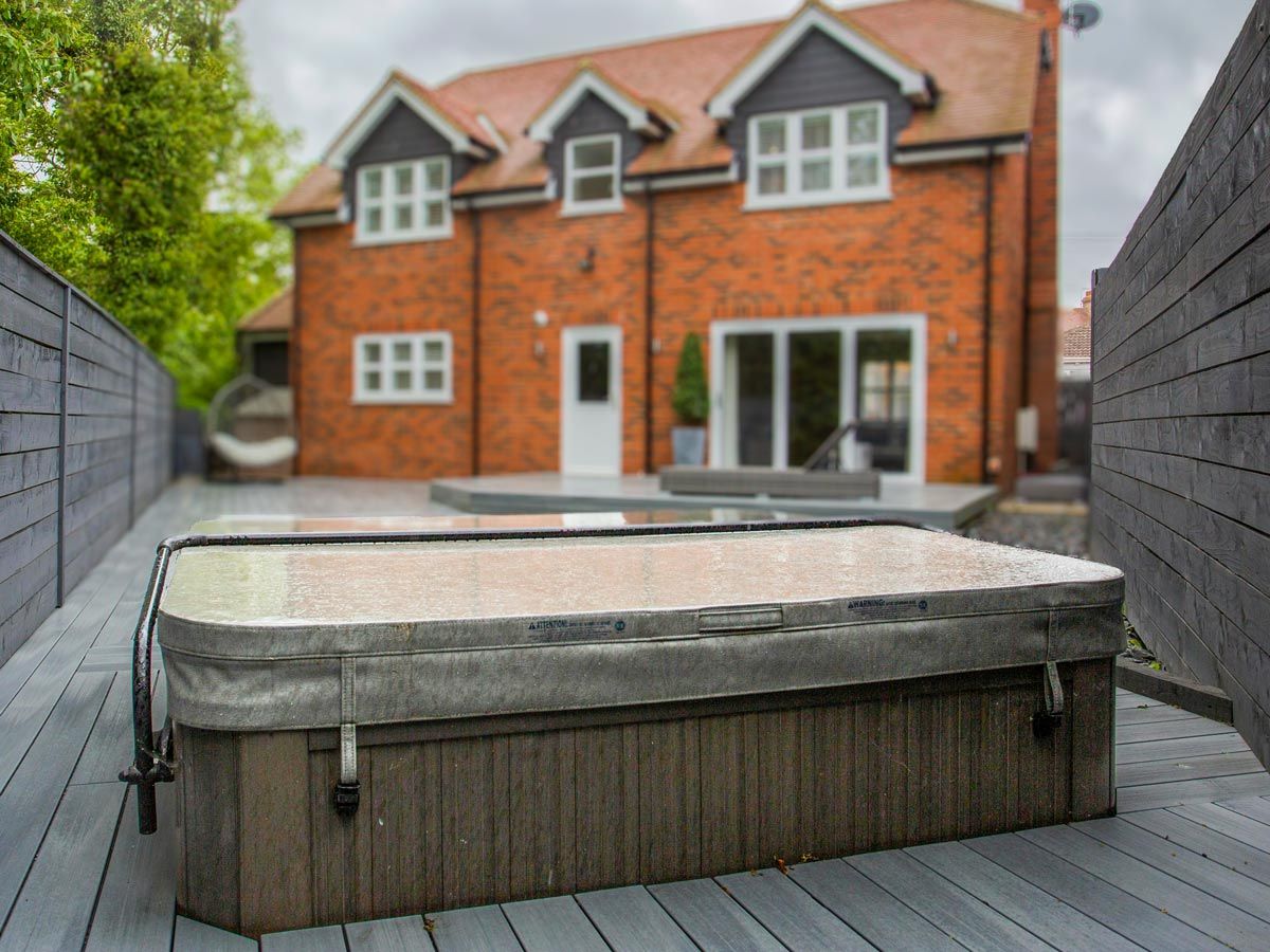 A semi sunken hot tub in the back garden of a new build townhouse