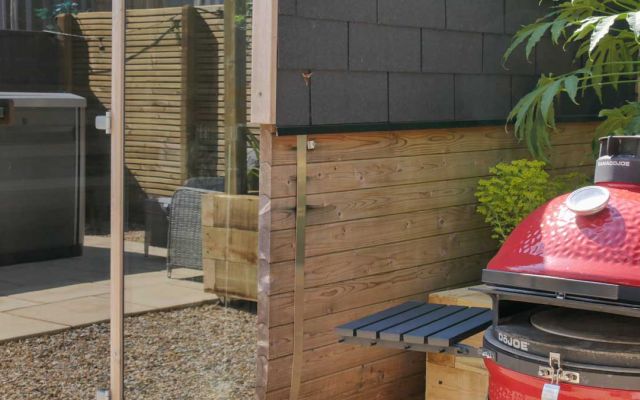 A Kamado Joe Grill outside the outdoor sauna