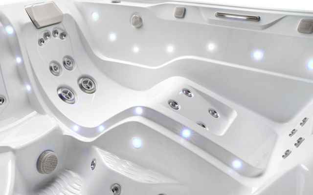 Four friends enjoying time in a Limelight Flair hot tub on a sunny day