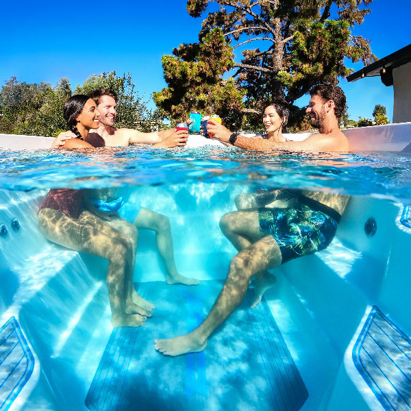 Four friends socialising in a RecSport spa, with the image taken in such a way that you can see what is both above and below the waterline