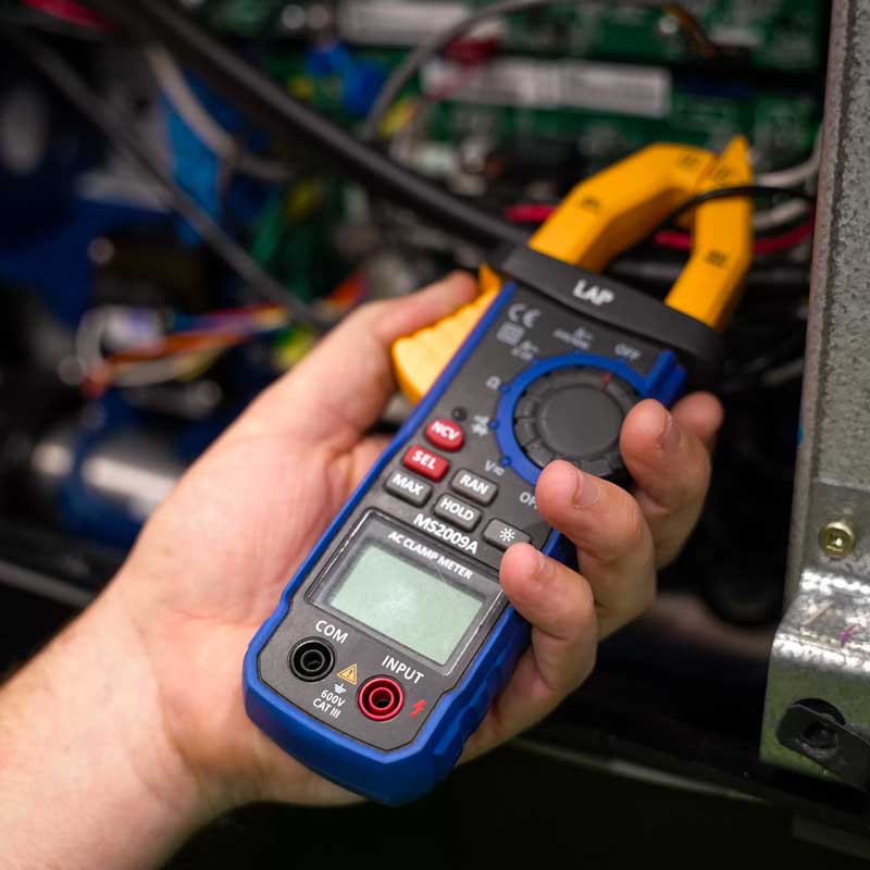 An AC clamp meter being used to diagnose a fault